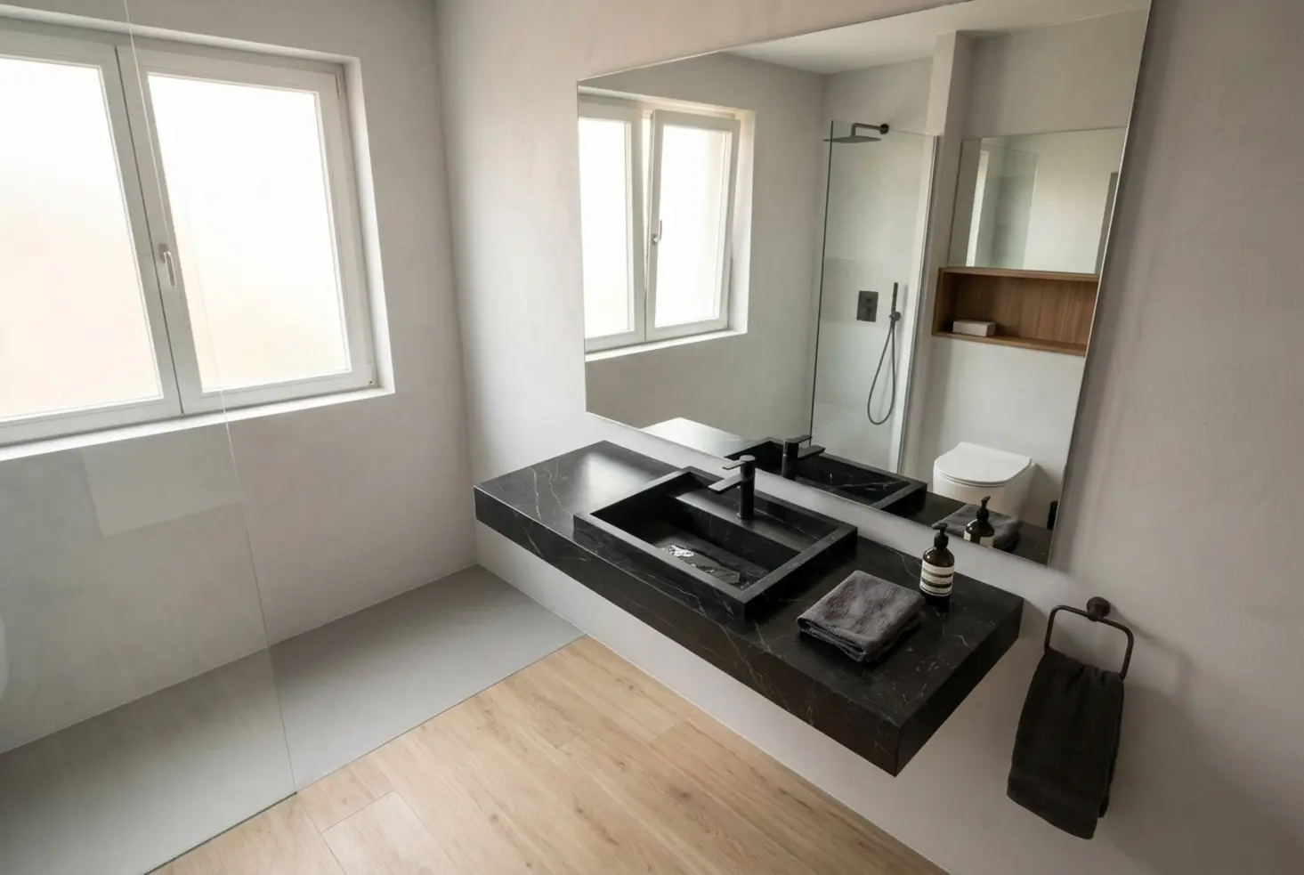 Cuarto de baño moderno diseñado por expertos en baños con lavabo de mármol negro
