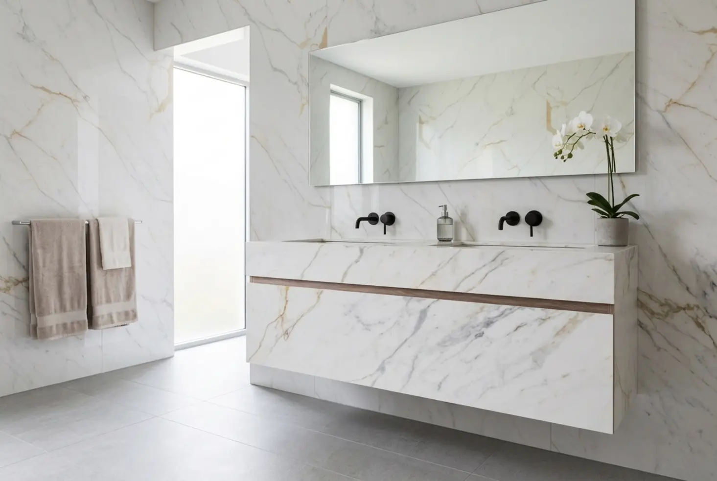 Mueble bajo lavabo flotante de mármol blanco con vetas doradas en baño de lujo